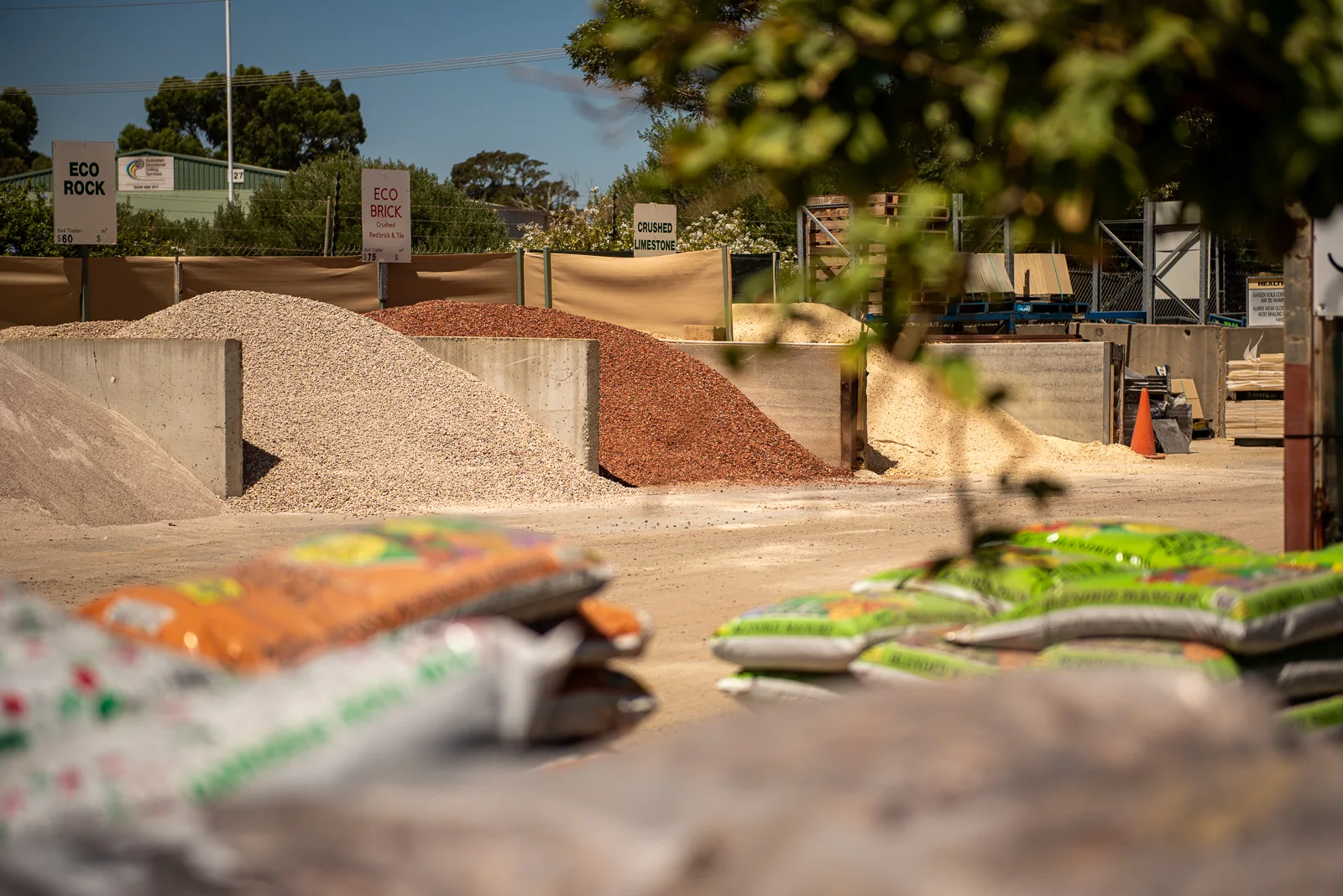 Product bays at the Bibra Lake Soils Bibra Lake yard — eco rock, eco brick and crushed limestone, with the bagged range in front